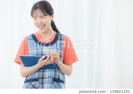 A woman with an apron with a tablet 139601291