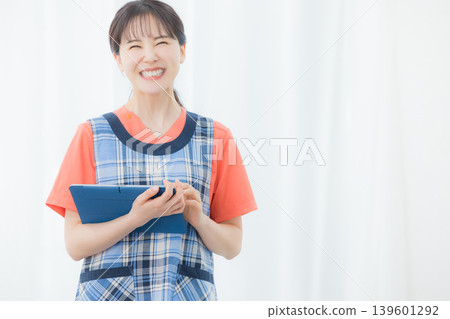 A woman with an apron with a tablet 139601292