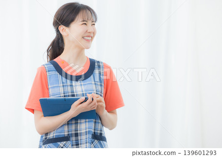 有圍裙的一名婦女與片劑 有圍裙的一名婦女與片劑 139601293
