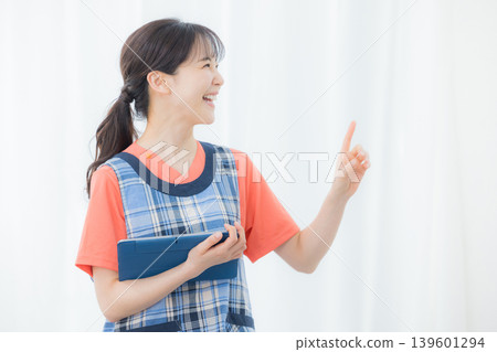 有圍裙的一名婦女與片劑 有圍裙的一名婦女與片劑 139601294