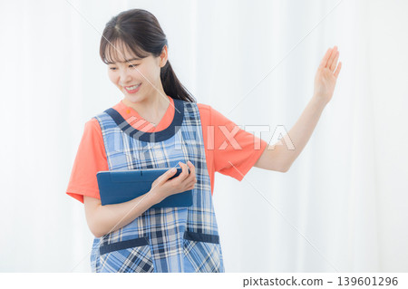 有圍裙的一名婦女與片劑 有圍裙的一名婦女與片劑 139601296