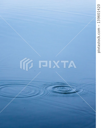 Spring waterside: Ripples from raindrops falling on the water's surface 01 139601420