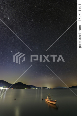 Summer starry sky over the Seto Inland Sea: Orion rising in the sky above the fishing port. Summer starry sky over the Seto Inland Sea: Orion rising in the sky above the fishing port. 139601501