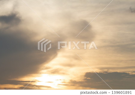 Atmospheric evening sky filled with layered clouds and warm glowing sunlight, creating a peaceful natural background with soft golden tones and dramatic texture. Atmospheric evening sky filled with layered clouds and warm glowing sunlight, creating a peaceful natural background with soft golden tones and dramatic texture. 139601891