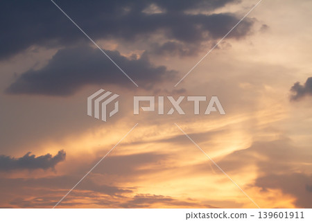 Warm sunset colors blend with layered clouds and fading daylight, creating a peaceful atmospheric sky scene with dramatic natural textures and glowing tones. Warm sunset colors blend with layered clouds and fading daylight, creating a peaceful atmospheric sky scene with dramatic natural textures and glowing tones. 139601911