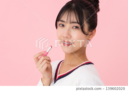 一位年輕女子拿著口紅 一位年輕女子拿著口紅 139602020