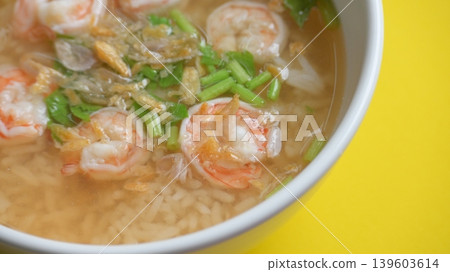 rice soup with shrimp in white bowl on yellow background 139603614