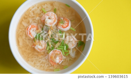 rice soup with shrimp in white bowl on yellow background 139603615