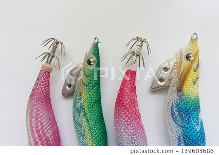從正上方拍攝的各種色彩鮮豔的魷魚鉤(egi),背景為白色。 從正上方拍攝的各種色彩鮮豔的魷魚鉤(egi),背景為白色。 139603686