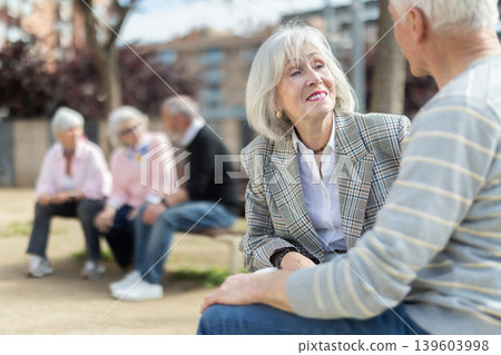 Happy senior couple flirting on bench outdoors Happy senior couple flirting on bench outdoors 139603998