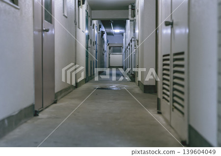 A low-angle view of the common corridor of an apartment complex at night. A low-angle view of the common corridor of an apartment complex at night. 139604049