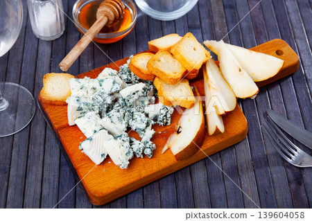 Soft roncari blue cheese with pear, croutons and honey on wooden board Soft roncari blue cheese with pear, croutons and honey on wooden board 139604058