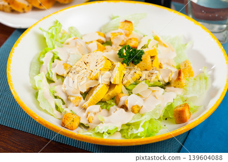 Caesar salad with grilled chicken on a white plate Caesar salad with grilled chicken on a white plate 139604088