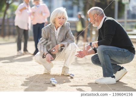 Elderly people analyzing the game results while playing petanca Elderly people analyzing the game results while playing petanca 139604156