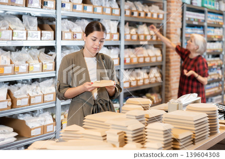 Young woman chooses blanks for making pottery Young woman chooses blanks for making pottery 139604308