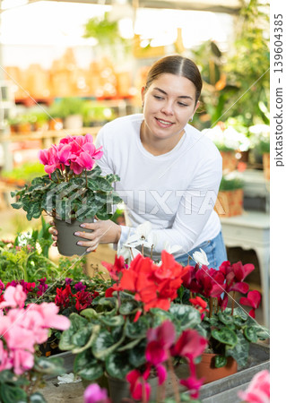 Woman buying cyclamen at flower shop Woman buying cyclamen at flower shop 139604385