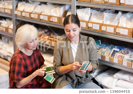 Elderly woman and young woman choose shade of paint from palette Elderly woman and young woman choose shade of paint from palette 139604458