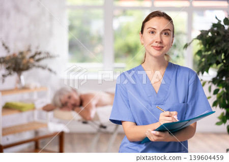 Young woman masseuse makes notes in spa salon 139604459
