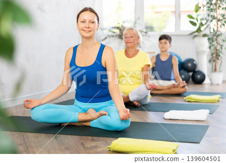 Group of people generation on mats doing yoga exercise lord of fishes pose. Group of people generation on mats doing yoga exercise lord of fishes pose. 139604501