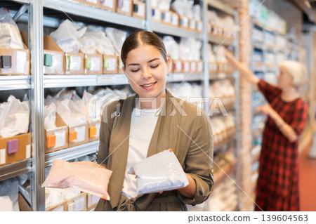 Young woman chooses pack of dry clay 139604563