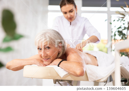 Elderly woman satisfied with work of masseuse Elderly woman satisfied with work of masseuse 139604605