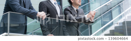 A faceless banner depicting a three-person team in front of an outdoor building, showing a positive and forward-thinking boss watching over his younger subordinates. A faceless banner depicting a three-person team in front of an outdoor building, showing a positive and forward-thinking boss watching over his younger subordinates. 139604664