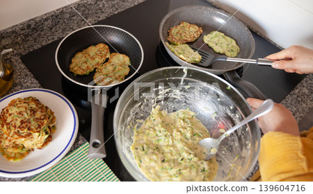 Process of cooked tasty zucchini pancakes in frying pan Process of cooked tasty zucchini pancakes in frying pan 139604716