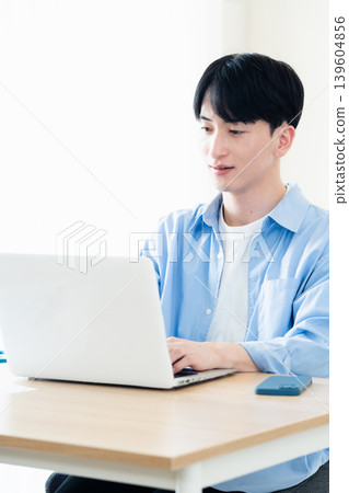 A young man who operates a computer A young man who operates a computer 139604856