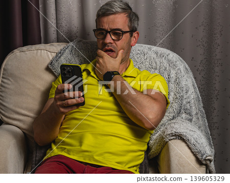 Freelancer checking bad news on mobile phone at night Freelancer checking bad news on mobile phone at night 139605329