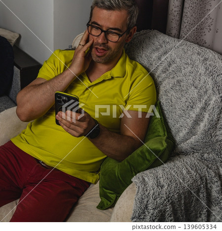 Happy man reacting positively to mobile phone message Happy man reacting positively to mobile phone message 139605334