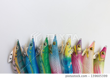Colorful squid jigs (egi) lined up against a white background and copy space Colorful squid jigs (egi) lined up against a white background and copy space 139605399