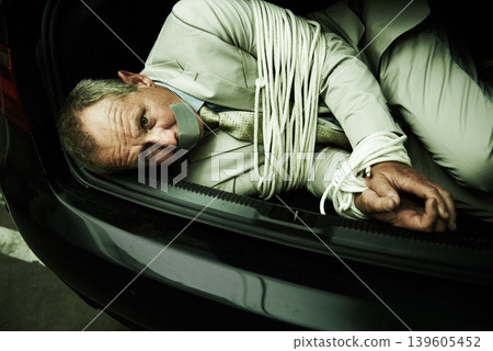 Car boot, hostage or portrait of business man with tape, rope and kidnap danger in parking lot. Fear, stress and face of male victim in a vehicle trunk with anxiety, horror or crime, scared or ransom 139605452