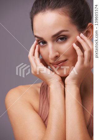 Portrait, beauty and aesthetic with natural woman in studio on gray background for wellness or dermatology. Skincare, makeup or cosmetics with hands of young person on face for antiaging treatment Portrait, beauty and aesthetic with natural woman in studio on gray background for wellness or dermatology. Skincare, makeup or cosmetics with hands of young person on face for antiaging treatment 139605574