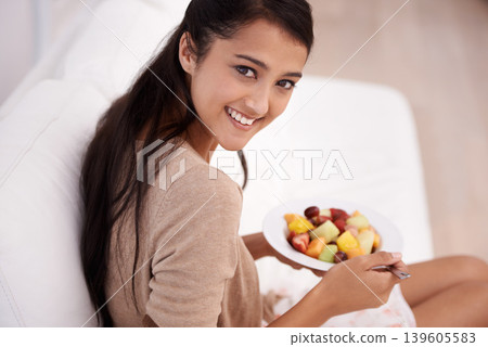 Happy woman, portrait and bowl of fruit salad for diet, nutrition or healthy snack on sofa at home. Face of young female person, nutritionist or vegan smile and eating breakfast for vitamin c or meal Happy woman, portrait and bowl of fruit salad for diet, nutrition or healthy snack on sofa at home. Face of young female person, nutritionist or vegan smile and eating breakfast for vitamin c or meal 139605583