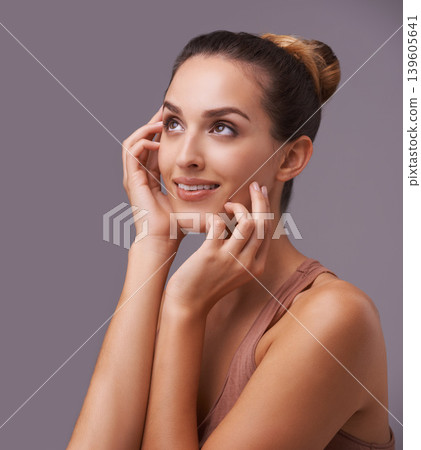 Woman, hands on face and beauty, skincare with dermatology and natural cosmetics on purple background. Healthy skin glow, happy with smile and wellness, self care and grooming for hygiene in studio Woman, hands on face and beauty, skincare with dermatology and natural cosmetics on purple background. Healthy skin glow, happy with smile and wellness, self care and grooming for hygiene in studio 139605641