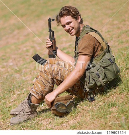 Military, smile and nature with man in and gun for war, conflict and patriotism. Army, surveillance and security with young person and rifle training on grass for soldier, battlefield and veteran 139605834