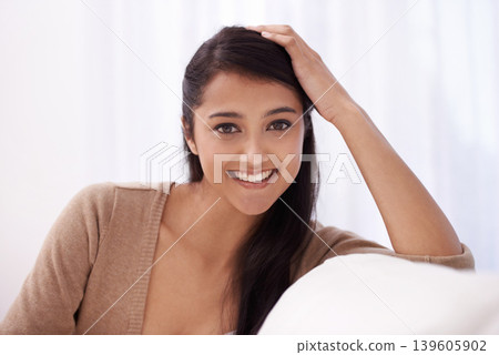 Woman, portrait and smile in a new home on a living room sofa relax in the morning. Lounge, happy face and female person from India on a couch in a house on the weekend with comfort and rest Woman, portrait and smile in a new home on a living room sofa relax in the morning. Lounge, happy face and female person from India on a couch in a house on the weekend with comfort and rest 139605902