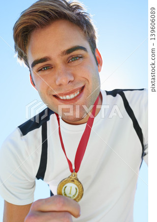 Winner, athlete and sports medal for achievement, success and portrait in running competition. Happy face of a young runner or man with red and gold award for contest or marathon on a blue sky Winner, athlete and sports medal for achievement, success and portrait in running competition. Happy face of a young runner or man with red and gold award for contest or marathon on a blue sky 139606089