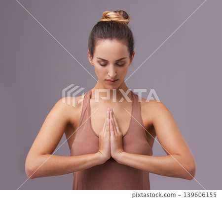 Prayer, face or woman in meditation in studio for wellness, peace or balance on purple background. Calm, relax or zen female model in yoga pose for energy, mental health or holistic breathing Prayer, face or woman in meditation in studio for wellness, peace or balance on purple background. Calm, relax or zen female model in yoga pose for energy, mental health or holistic breathing 139606155