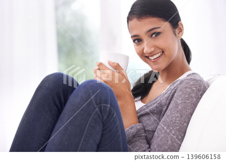 Coffee, home and portrait of Indian woman on sofa for relaxing, comfortable and calm in morning. Apartment, happy and person with mug on couch drinking hot beverage, tea and caffeine in living room Coffee, home and portrait of Indian woman on sofa for relaxing, comfortable and calm in morning. Apartment, happy and person with mug on couch drinking hot beverage, tea and caffeine in living room 139606158