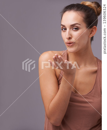 Portrait of woman, blow kiss or skincare with beauty or cosmetics for healthy glow or results. Isolated, flirting or confident model with natural shine or wellness in studio on purple background Portrait of woman, blow kiss or skincare with beauty or cosmetics for healthy glow or results. Isolated, flirting or confident model with natural shine or wellness in studio on purple background 139606324