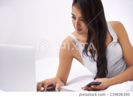 Woman, laptop and phone on bed for planning, reading website and research of home education or e learning. Young person or student relax in bedroom with computer, mobile and social media or studying 139606360