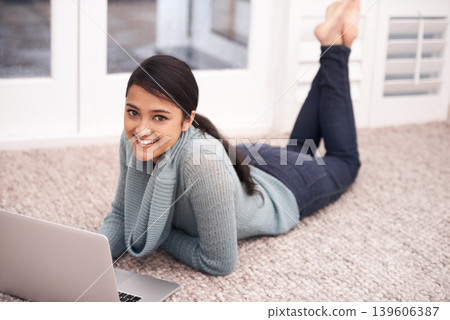 Portrait of woman on floor with laptop, smile and relax with studying, college research and browse on web. University student girl on carpet with computer, elearning and online education in home. Portrait of woman on floor with laptop, smile and relax with studying, college research and browse on web. University student girl on carpet with computer, elearning and online education in home. 139606387