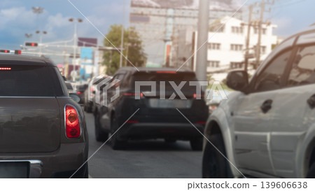 Heavy traffic congestion showing multiple cars closely packed on a city road. The view highlights the rear of a brown SUV and a white car. Capturing the atmosphere of a busy rush hour. Heavy traffic congestion showing multiple cars closely packed on a city road. The view highlights the rear of a brown SUV and a white car. Capturing the atmosphere of a busy rush hour. 139606638