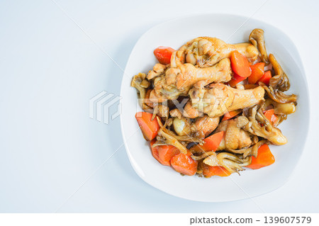 Braised chicken wings and carrots, a Japanese-style stew with mushrooms, against a white background. Braised chicken wings and carrots, a Japanese-style stew with mushrooms, against a white background. 139607579