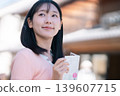 一位女士在川越——「小江戶」——的街道上漫步，手持宣傳冊，背景是川越的鐘樓。 （埼玉縣旅遊圖片） 139607715