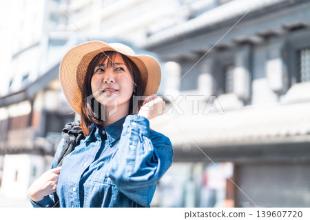A smiling Japanese woman walks through a historic townscape. Summer domestic travel image. A smiling Japanese woman walks through a historic townscape. Summer domestic travel image. 139607720