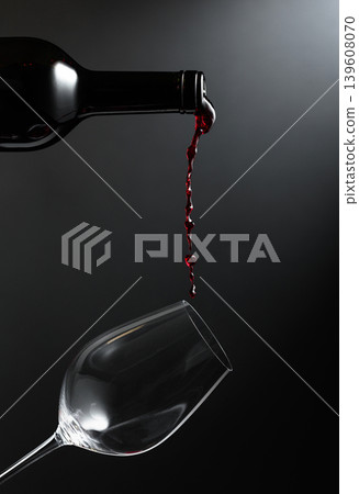 Red wine of rich color being poured from a bottle into a glass. 139608070