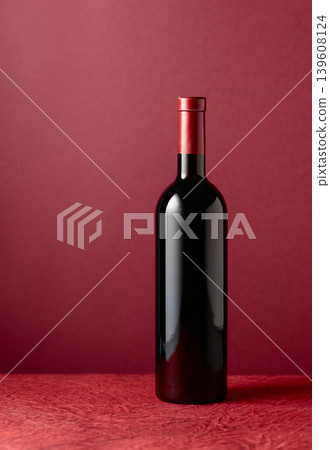 Bottle of red wine on a red background. Bottle of red wine on a red background. 139608124