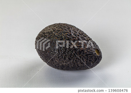 Whole ripe Hass avocados on a textured grey stone background. Whole ripe Hass avocados on a textured grey stone background. 139608476